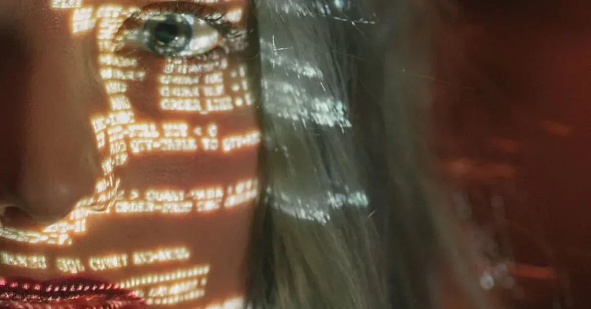 Code projected onto a person's eye and face, symbolizing digital surveillance and the impact of data monitoring on individual privacy.